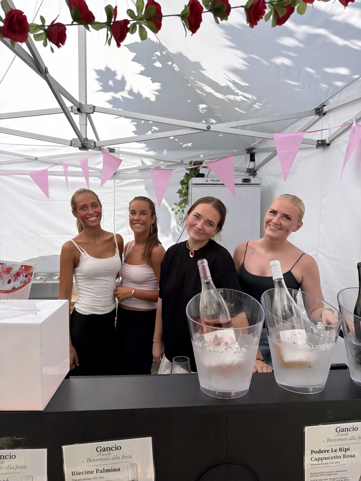 Gancios personale bag baren i festivalteltet med rosévin på køl og lyserøde vimpler
